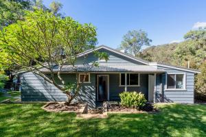 ein kleines blaues Haus mit einem Baum im Hof in der Unterkunft Coal and Candle by Beach Stays in Berowra