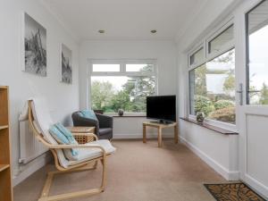 a living room with a tv and a chair at Polkerris View in St Austell