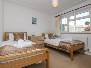 a bedroom with two beds and a window at Polkerris View in St Austell