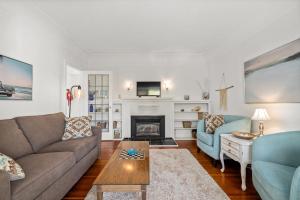 sala de estar con sofá y chimenea en Coastal Chic Retreat by Iris Properties!, en Victoria