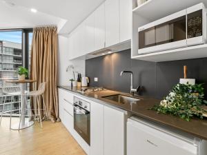 a kitchen with a sink and a counter top at Brand-New Central Studio Apart with Views in Brisbane