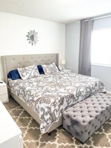 a white bedroom with a large bed with a bedskirtspectspectspects at Modern and Spacious Home near downtown and UNL in Lincoln