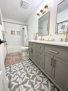 a bathroom with a sink and a toilet and a mirror at Modern and Spacious Home near downtown and UNL in Lincoln