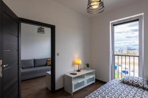 a bedroom with a bed and a window with a couch at ENERGYLANDIA Zator Apartament Grześ in Zator