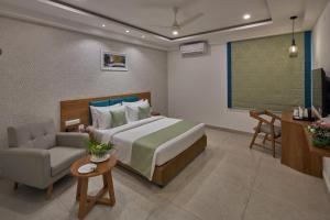 バンガロールにあるRegenta Inn 4th Block Koramangala Bangaloreのベッドルーム1室(ベッド1台、ソファ、テーブル付)