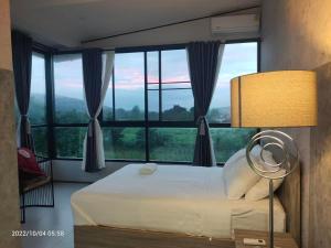 sypialnia z łóżkiem i dużym oknem w obiekcie 88 ลิฟวิ่ง โฮเทล ปากช่อง w mieście Ban Sathani Bandai Ma