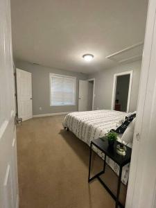 a bedroom with a bed and a table in it at Full house charm mins frm DT Raleigh, NC State University in Raleigh