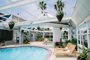 una piscina coperta in una casa con giardino d'inverno di Laguna Surf Lodge by SCP Hotels a Laguna Beach