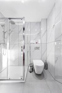 a white bathroom with a toilet and a shower at Golders Green Stays in London