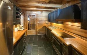 a kitchen with wooden counters and a refrigerator at Beautiful Home In stby With Sauna And 4 Bedrooms in Østby