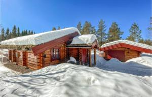 a log cabin with snow on the roof at Beautiful Home In stby With Sauna And 4 Bedrooms in Østby