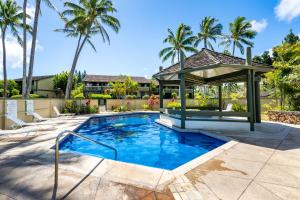 a swimming pool with a gazebo and palm trees at Bamboo Hale - Golf Course View - Sleeps 2 in Kahuku