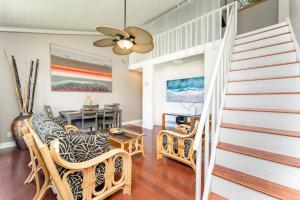 a living room with a staircase and a table at Bamboo Hale - Golf Course View - Sleeps 2 in Kahuku