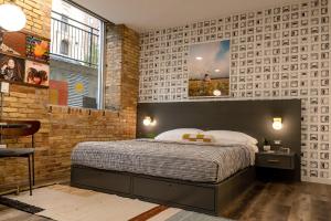 a bedroom with a bed and a brick wall at 5 King Bed Suites at The Finnley Hotel in DT GR in Grand Rapids