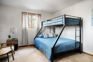 - une chambre avec des lits superposés et des draps bleus dans l'établissement Cabin w Hot Tub, Indoor Pool, Gym Access, & Grill, à Hedgesville