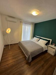Un dormitorio con una cama grande con una pared verde. en Holiday Home Lany, en Mravince