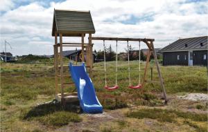 a playground with a blue slide and a tower at Holiday Home Hvide Sande 31 in Bjerregård