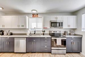 a kitchen with white cabinets and stainless steel appliances at Near City Center - Full Kitchen - Fast Wi-Fi in Salt Lake City