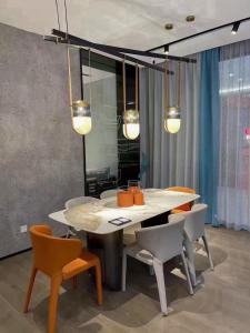 uma sala de jantar com mesa, cadeiras e luzes em căn hộ OCEANVISTA em Ấp Phú Tịnh (2)