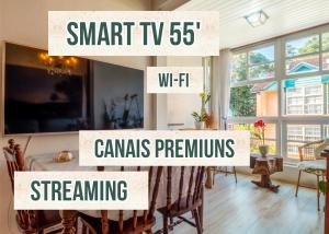 a dining room with a table and chairs with the words smart tv wifi channels at Belíssimo Duplex a 500m Lago Neg 3Q 4bikes Churrasq lareira Ar QF in Gramado