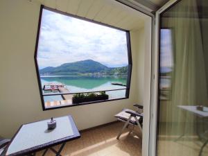 a room with a large window with a view of a lake at Haus am See in Sankt Kanzian