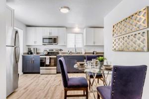 a kitchen with a glass table and blue chairs at King Bed - Fast WiFi - Sugarhouse Health Center in Salt Lake City