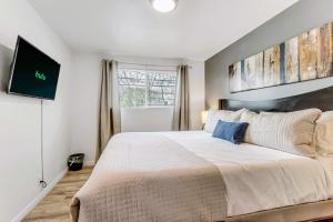 1 dormitorio con 1 cama grande y TV en la pared en King Bed - Fast WiFi - Sugarhouse Health Center en Salt Lake City