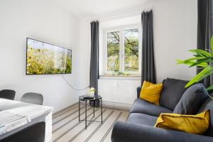 uma sala de estar com um sofá azul e almofadas amarelas em Apartment an der Theresienwiese em Munique