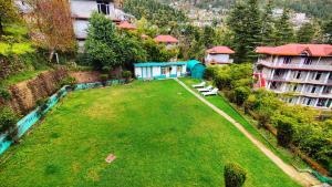 an aerial view of a large grassy yard with buildings at Gagan Resorts in Dharamshala