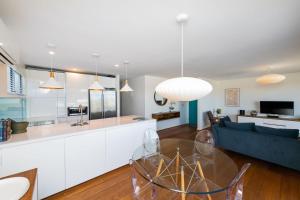 a kitchen and living room with a glass table at Griffin 184 Kingston Apartment in Kingston 