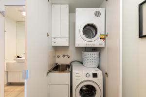 a small laundry room with a washer and dryer at Griffin 184 Kingston Apartment in Kingston 