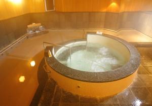 a large bath tub filled with water in a bathroom at Ooedo Onsen Monogatari Kimitsu no Mori in Kimitsu