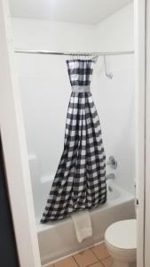a black and white checkered shower curtain in a bathroom at OSU 2 Queen Beds Hotel Room 224 Hot Tub Booking in Stillwater