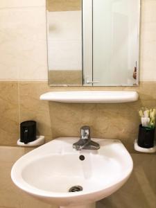 lavabo blanco en el baño con espejo en Van Thanh Hotel Cua Lo, en Cửa Lô