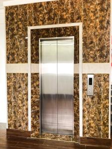 a metal elevator in a room with a stone wall at Van Thanh Hotel Cua Lo in Cửa Lô