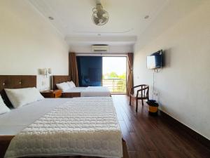 a hotel room with two beds and a television at Van Thanh Hotel Cua Lo in Cửa Lò