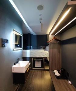a bathroom with a sink and a bed at HOTEL JJH - newly opened near BUGIS in Singapore