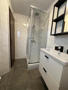 a white bathroom with a shower and a sink at Holiday Home Lany in Mravince