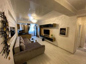 ein großes Wohnzimmer mit einem Sofa und einem TV in der Unterkunft Maria Ziana Residence Mamaia Nord in Complexul Building Stefan Resort in Mamaia Nord – Năvodari