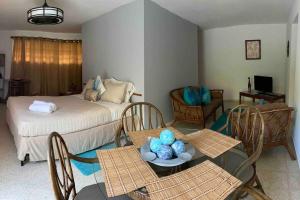 un soggiorno con letto, tavolo e sedie di Mayagüez Apt- up to 4 guests- Close to Everything a Mayaguez