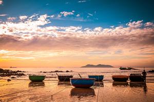 a group of boats sitting on the beach at sunset at Van Thanh Hotel Cua Lo in Cửa Lò