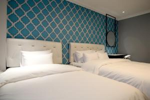GimcheonBaba Hotel Gimcheon的配有两张蓝色和白色壁纸的床铺
