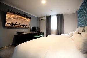 GimcheonBaba Hotel Gimcheon的卧室里有一张白色的大床和一台电视