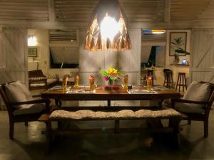 a dining room table with chairs and a chandelier at Corto Novo Maison d'hôtes-Camping in Nosy Be