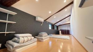 uma sala de estar com duas camas e uma parede em 和風庭園豪邸 em Osaka