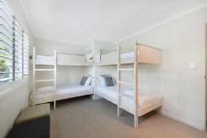 a room with two bunk beds and a window at Eagles Retreat Peregian Beach in Peregian Beach