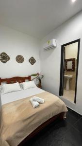 a bedroom with a bed with a mirror and a sink at HOSTEL M&H in Cartagena de Indias