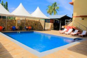 une piscine dans un hôtel avec des tentes blanches en arrière-plan dans l'établissement Tiffany Diamond Hotels - Mtwara, à Mtwara