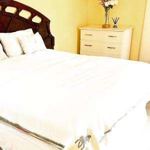 een slaapkamer met een wit bed en een dressoir bij 90@Berry in Queenstown