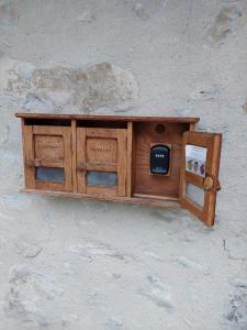a wooden cabinet with a tv on a wall at Aux Trois Soleils in Chexbres